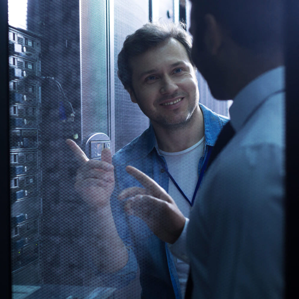 nice-positive-delighted-man-smiling-looking-his-colleague-while-pointing-usb-cables copy